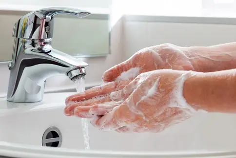 photo of washing hands in bathroom sink
